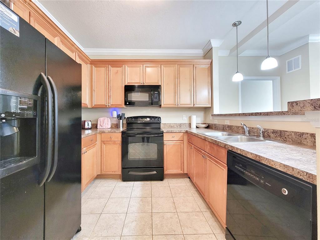 1185 Southwest 9th Road, Unit 306 Gainesville, FL 32601 - Photo 6 of 30 a kitchen with stainless steel appliances granite countertop a sink a stove a refrigerator and a microwave