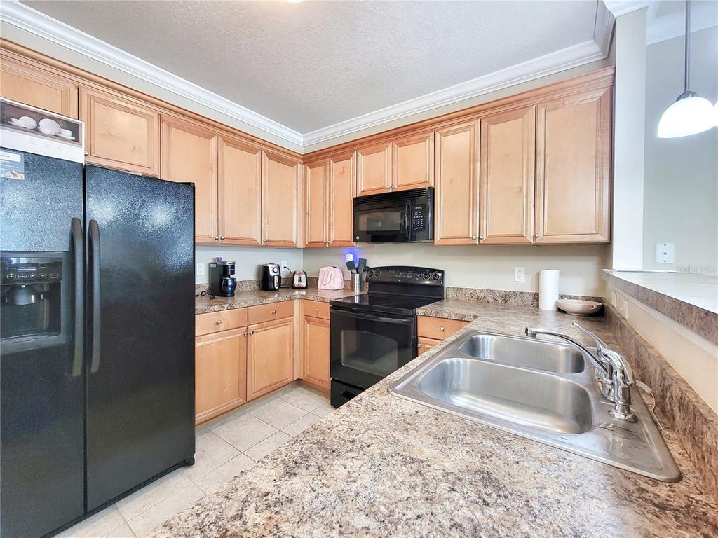 1185 Southwest 9th Road, Unit 306 Gainesville, FL 32601 - Photo 7 of 30 a kitchen with granite countertop a refrigerator stove and sink