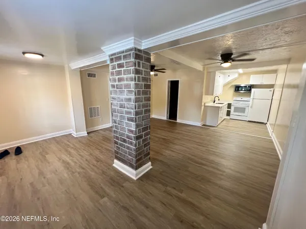 a view of empty room with wooden floor
