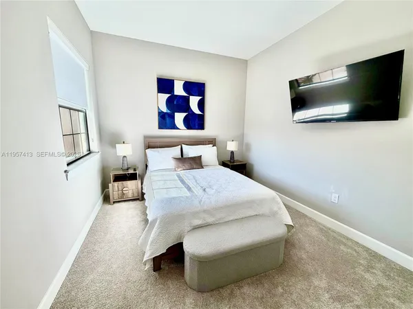 a bedroom with a bed and a flat screen tv