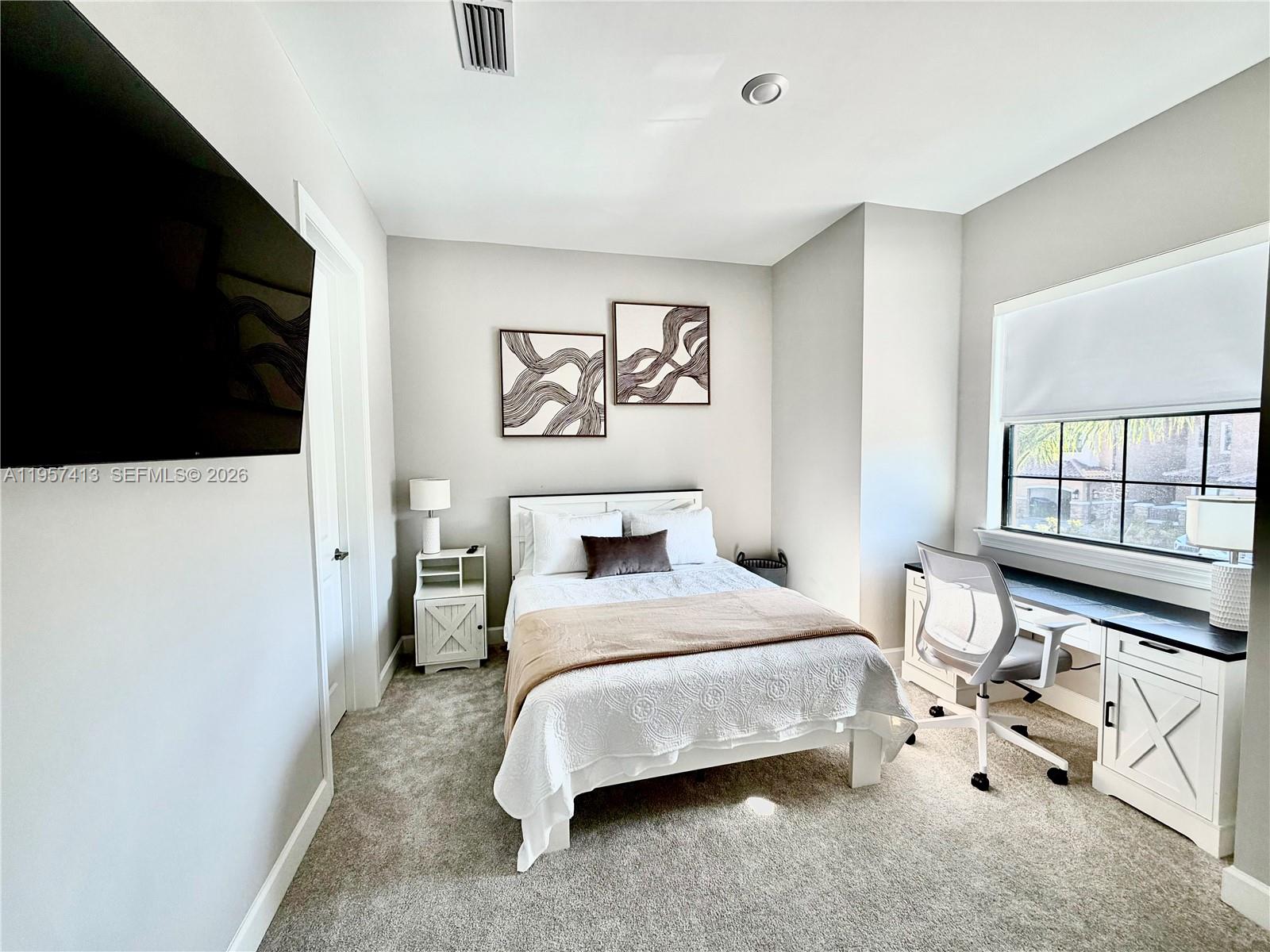 15323 Lucerna Street, Unit 204 Naples, FL 34114 - Photo 6 of 29 a bedroom with a bed and a flat tv screen on the dresser