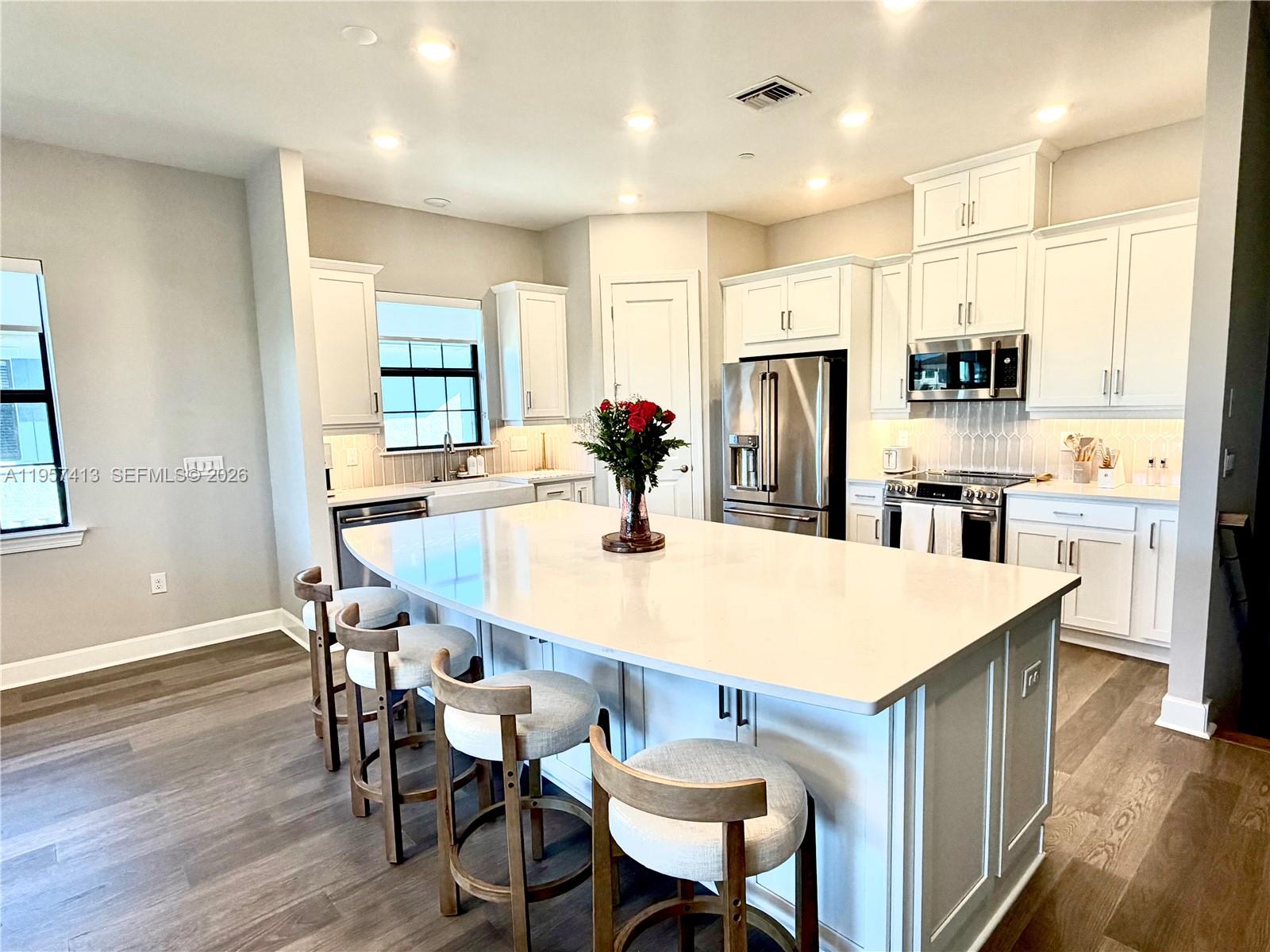 15323 Lucerna Street, Unit 204 Naples, FL 34114 - Photo 7 of 29 a kitchen with stainless steel appliances a dining table chairs microwave and sink