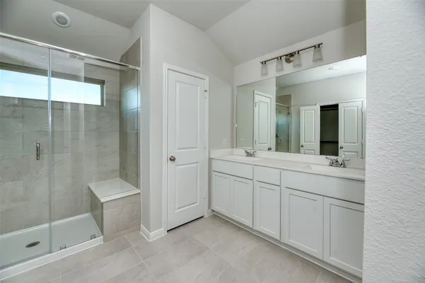 a spacious bathroom with a shower sink and mirror