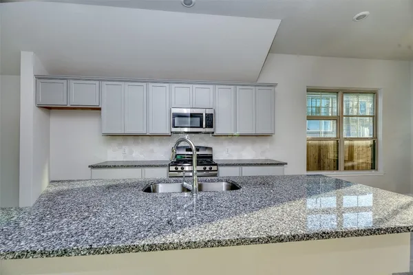 a kitchen with stainless steel appliances granite countertop a sink stove and granite counter top