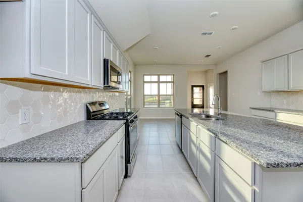 a kitchen with stainless steel appliances granite countertop a sink stove and cabinets