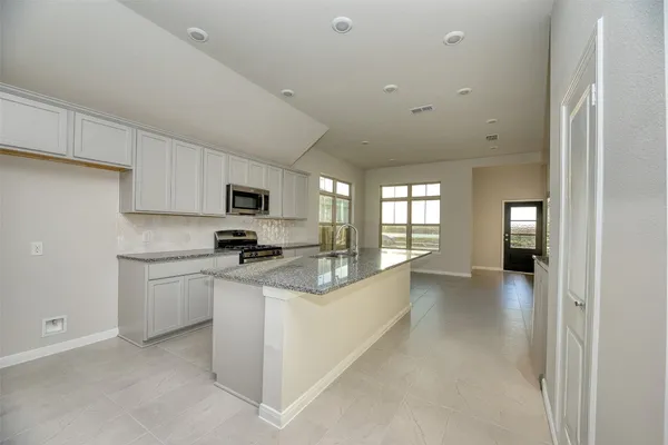 a kitchen with stainless steel appliances granite countertop a refrigerator and a stove top oven