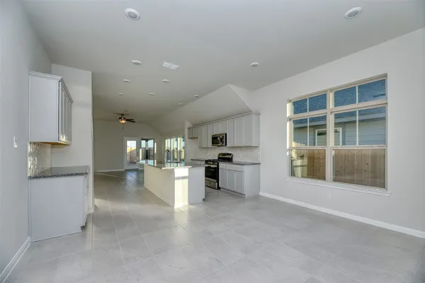 a large kitchen with a large counter top stainless steel appliances and cabinets