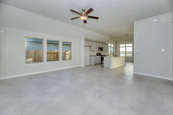 a view of a livingroom with a ceiling fan and kitchen view