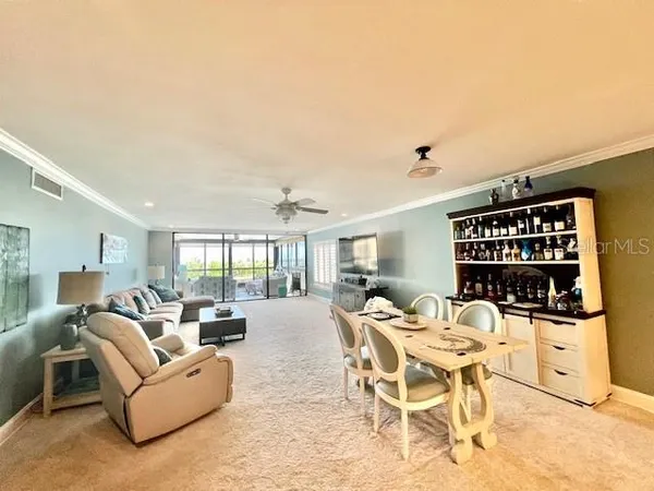 a living room with furniture a chandelier and a large window