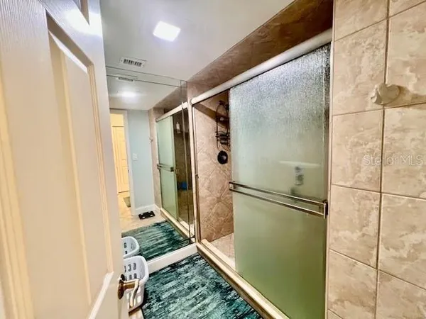 a bathroom with a glass shower door and a mirror