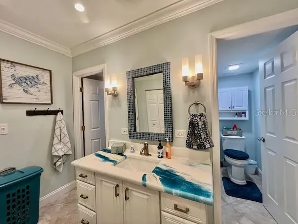 a bathroom with a granite countertop sink mirror vanity and toilet