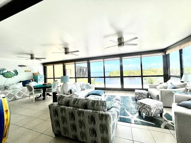 a living room with furniture and floor to ceiling windows