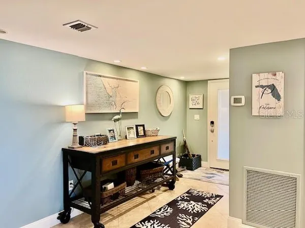 a room with a table chairs and a window