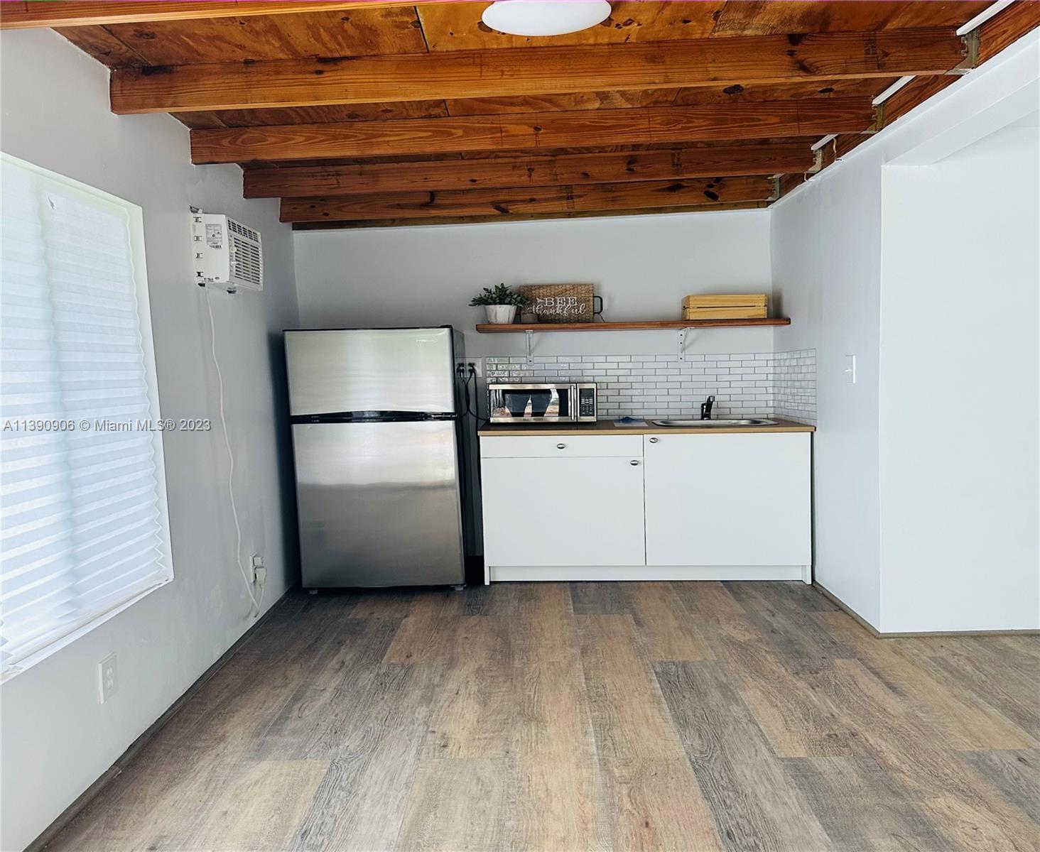 451 Southeast 8th Street Homestead, FL 33030 - Photo 3 of 10 a kitchen with granite countertop a wooden floor and cabinets