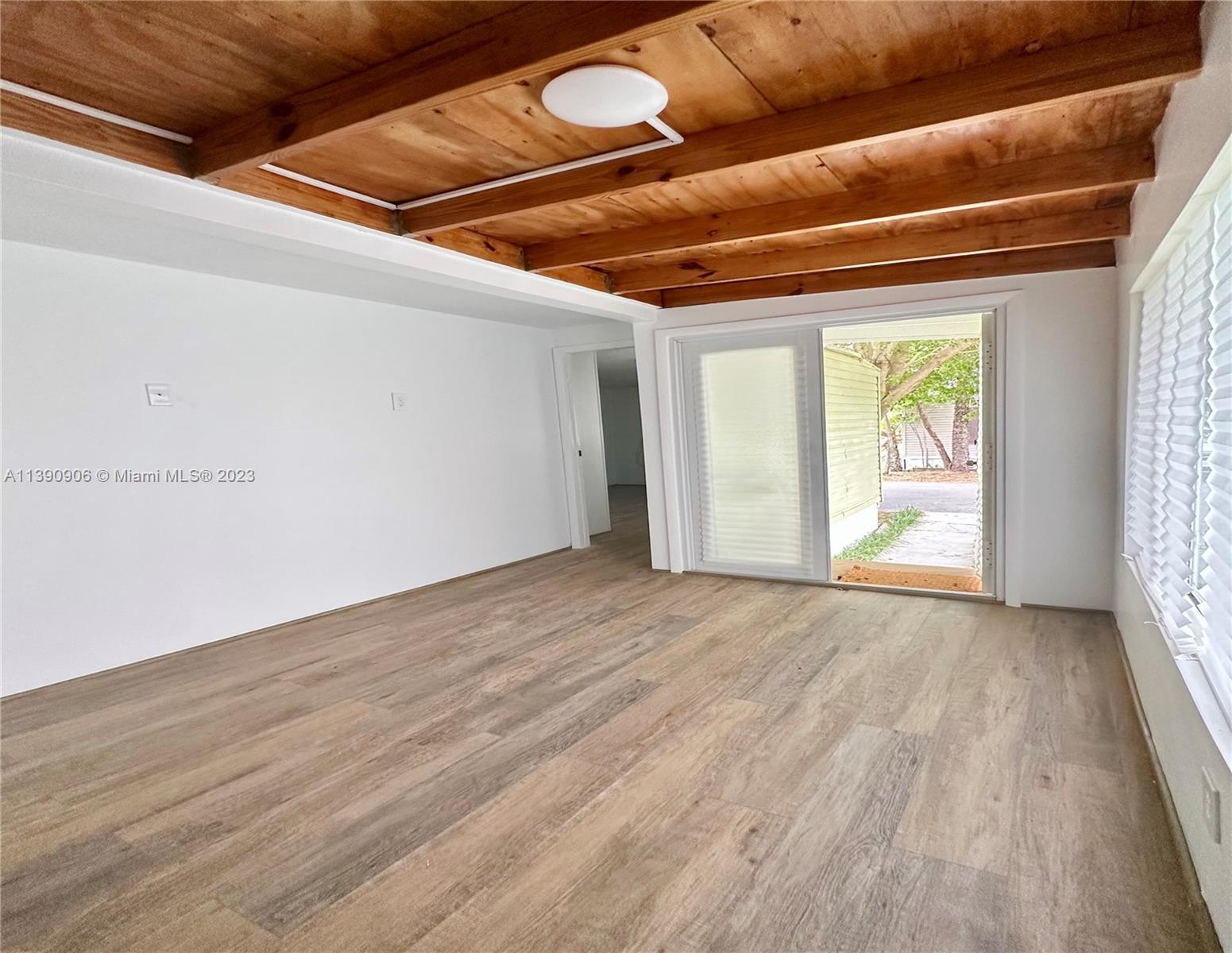 451 Southeast 8th Street Homestead, FL 33030 - Photo 4 of 10 a view of empty room with wooden floor and fan