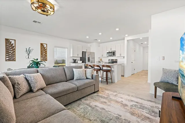 a living room with furniture and kitchen view