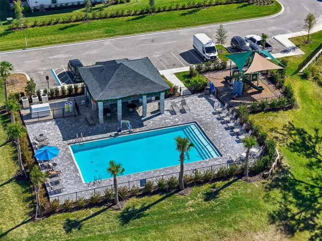 an aerial view of a house with a garden and lake