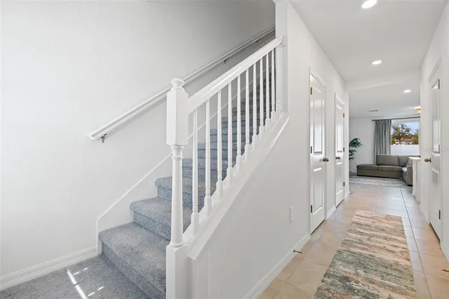 a view of a hallway with wooden floor and stairs