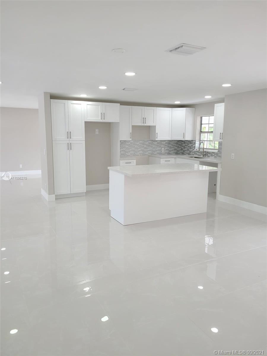 a large white kitchen with stainless steel appliances cabinets
