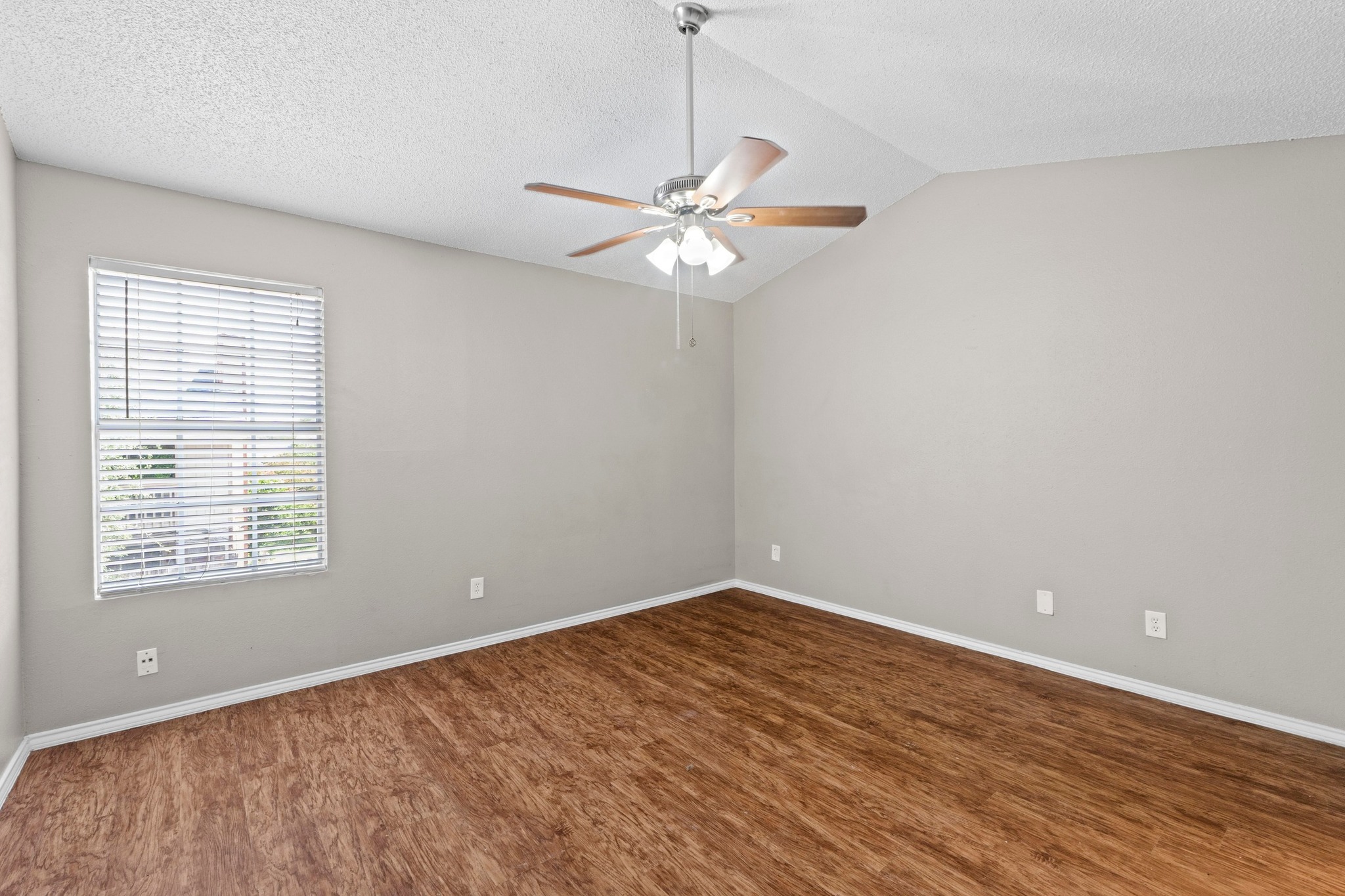 4208 Duval Road, Unit C Austin, TX 78759 - Photo 13 of 28 Unfurnished room featuring wood finished floors, a ceiling fan, lofted ceiling, and a textured ceiling