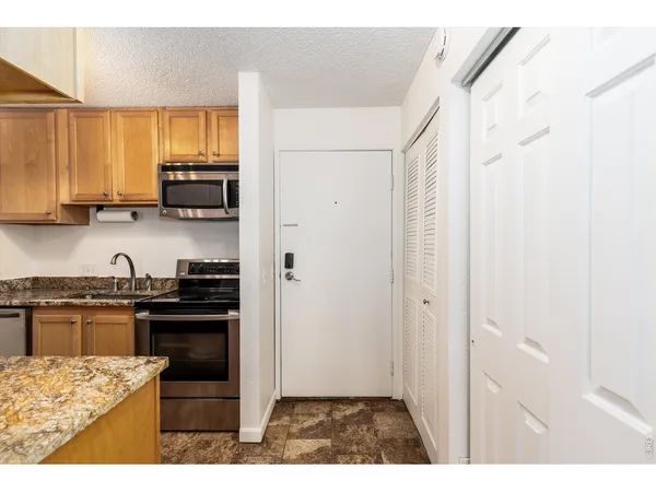a kitchen with stainless steel appliances granite countertop a stove a sink and a refrigerator