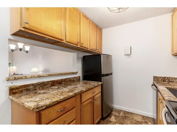 a kitchen with kitchen island granite countertop a stove and a refrigerator