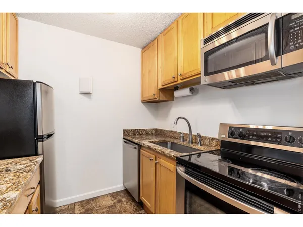 a kitchen with stainless steel appliances granite countertop a stove and a microwave