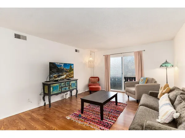 a living room with furniture a rug and a lamp
