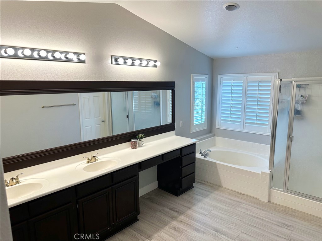 33878 Channel Street Temecula, CA 92592 - Photo 8 of 14 a bathroom with a double vanity sink a mirror and a bathtub