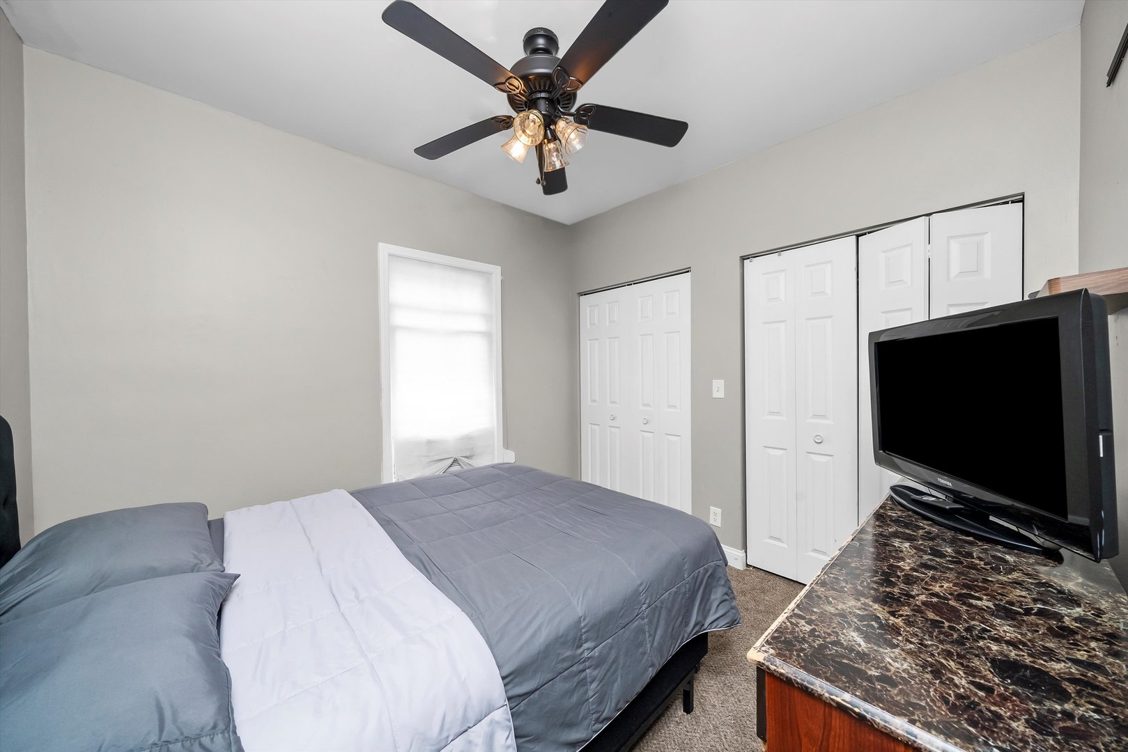 8808 South Loomis Street Chicago, IL 60620 - Photo 14 of 32 a bedroom with a bed and a flat screen tv