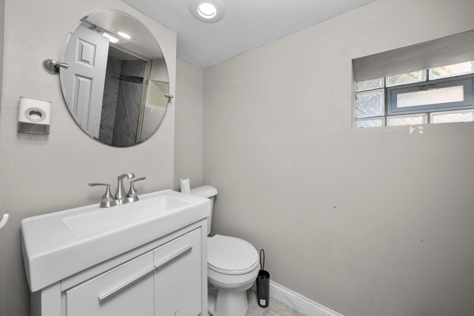 8808 South Loomis Street Chicago, IL 60620 - Photo 20 of 32 a bathroom with a toilet a sink and mirror