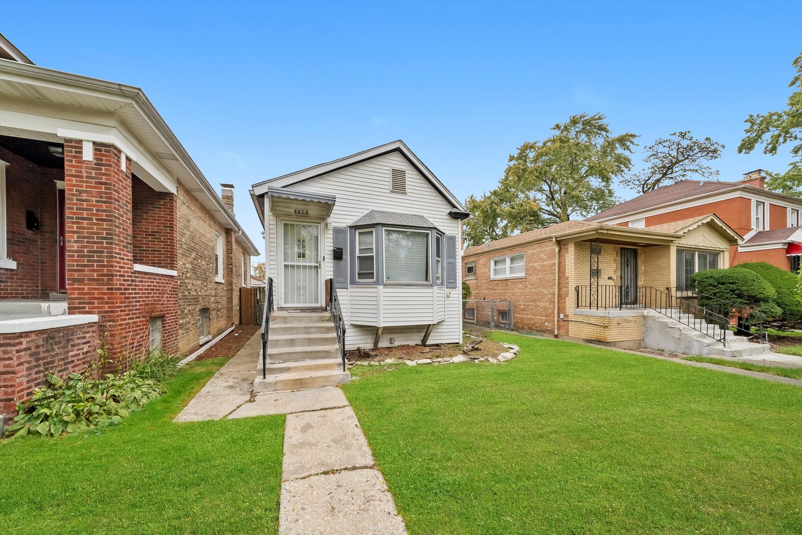 8808 South Loomis Street Chicago, IL 60620 - Photo 26 of 32 a front view of a house with a yard and porch