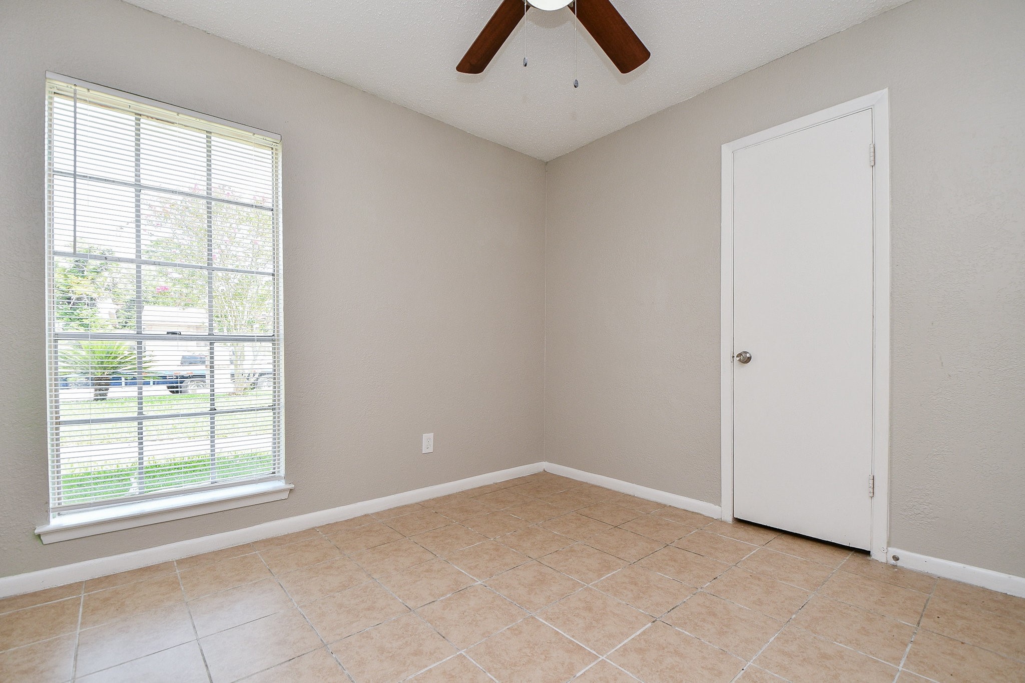 14902 Gloster Street Channelview, TX 77530 - Photo 11 of 21 an empty room with windows and fan