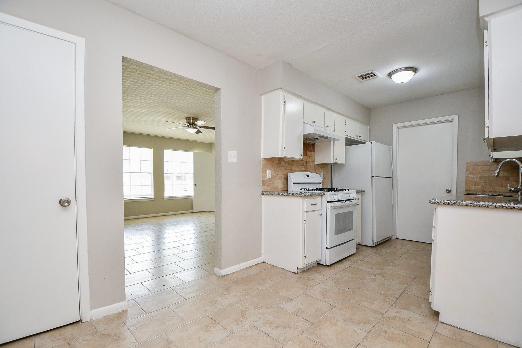 14902 Gloster Street Channelview, TX 77530 - Photo 5 of 21 a kitchen with white cabinets and white appliances