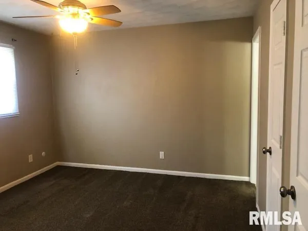 an empty room with a window and wooden floor