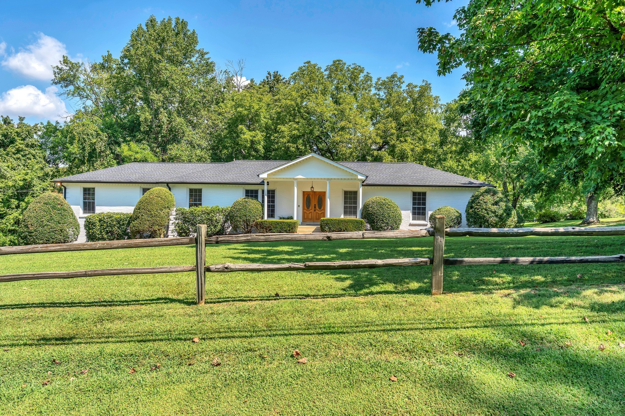 608 Hill Road Nashville, TN 37220 - Photo 6 of 44 a front view of a house with a yard table and trees