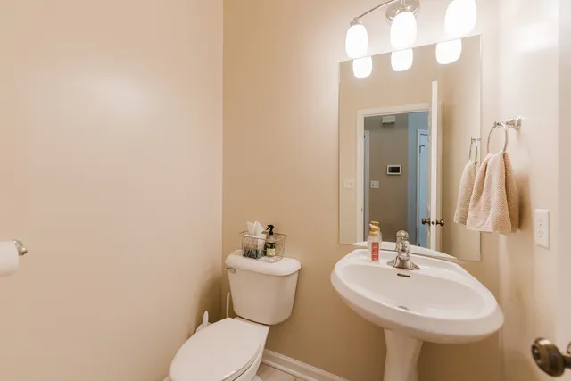 a bathroom with a sink and mirror with toilet