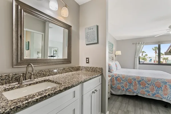 a kitchen with stainless steel appliances granite countertop a refrigerator a stove top oven a sink dishwasher and white cabinets with wooden floor