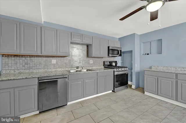a kitchen with cabinets appliances and a sink