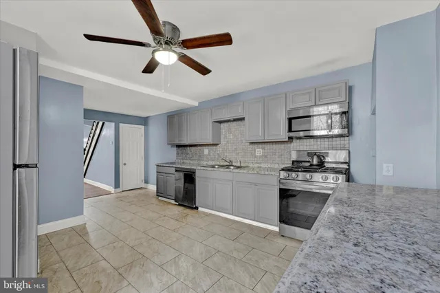 a kitchen with stainless steel appliances granite countertop a stove sink and refrigerator