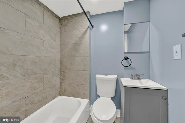 a white toilet sitting next to a bathroom sink and tub