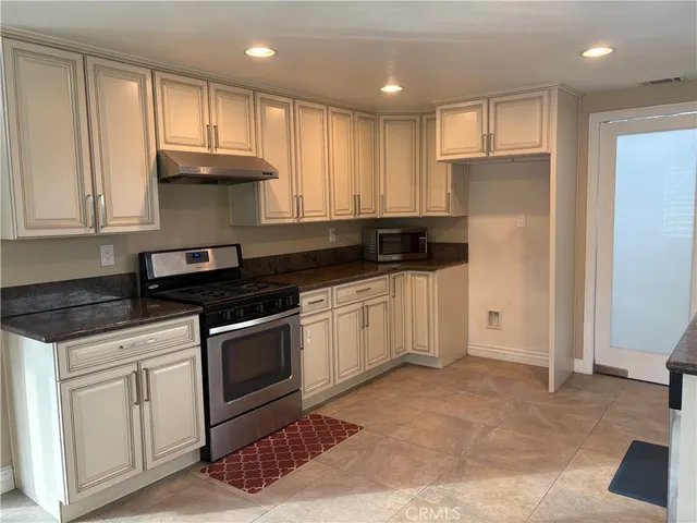 a kitchen with stainless steel appliances granite countertop a stove a sink and a refrigerator