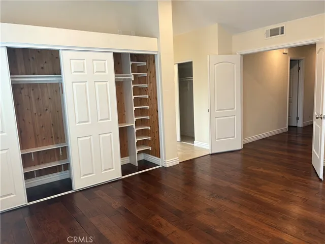 an empty room with wooden floor and closet