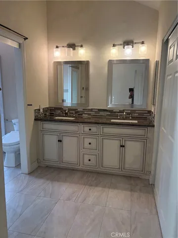 a spacious bathroom with a granite countertop sink and a mirror