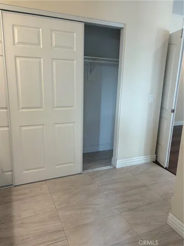 an empty room with a wooden door and cabinet