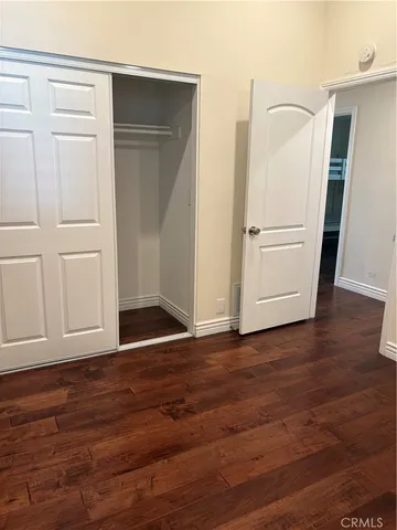 an empty room with wooden floor and closet