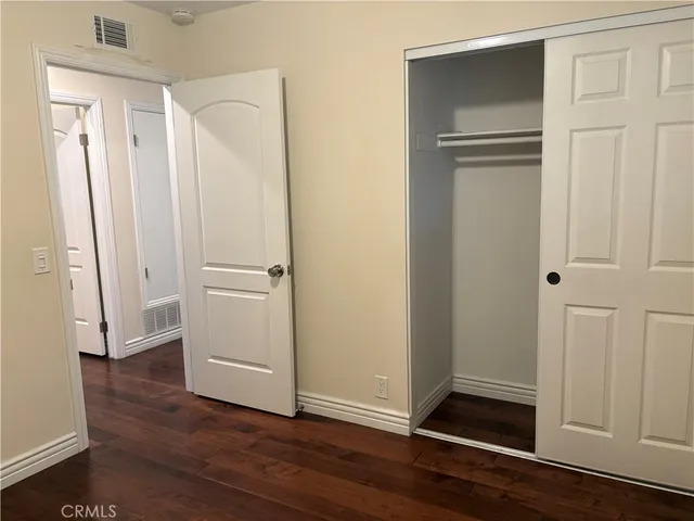 an empty room with wooden floor and closet