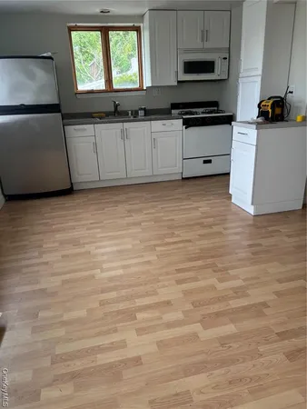 a kitchen with granite countertop a refrigerator and a stove top oven