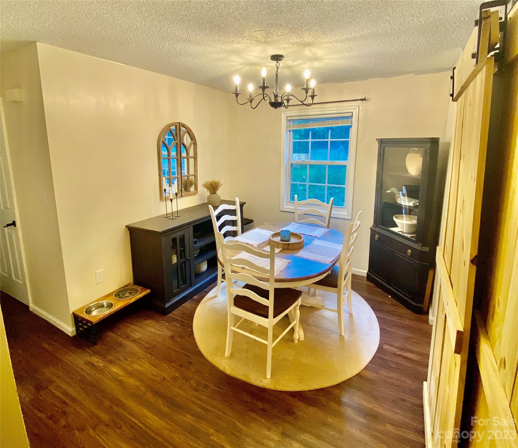 9701 Hambright Road Huntersville, NC 28078 - Photo 7 of 17 a dining room with wooden floor a chandelier a glass table and chairs