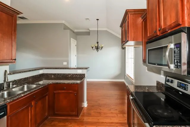 a kitchen with granite countertop a stove and a microwave
